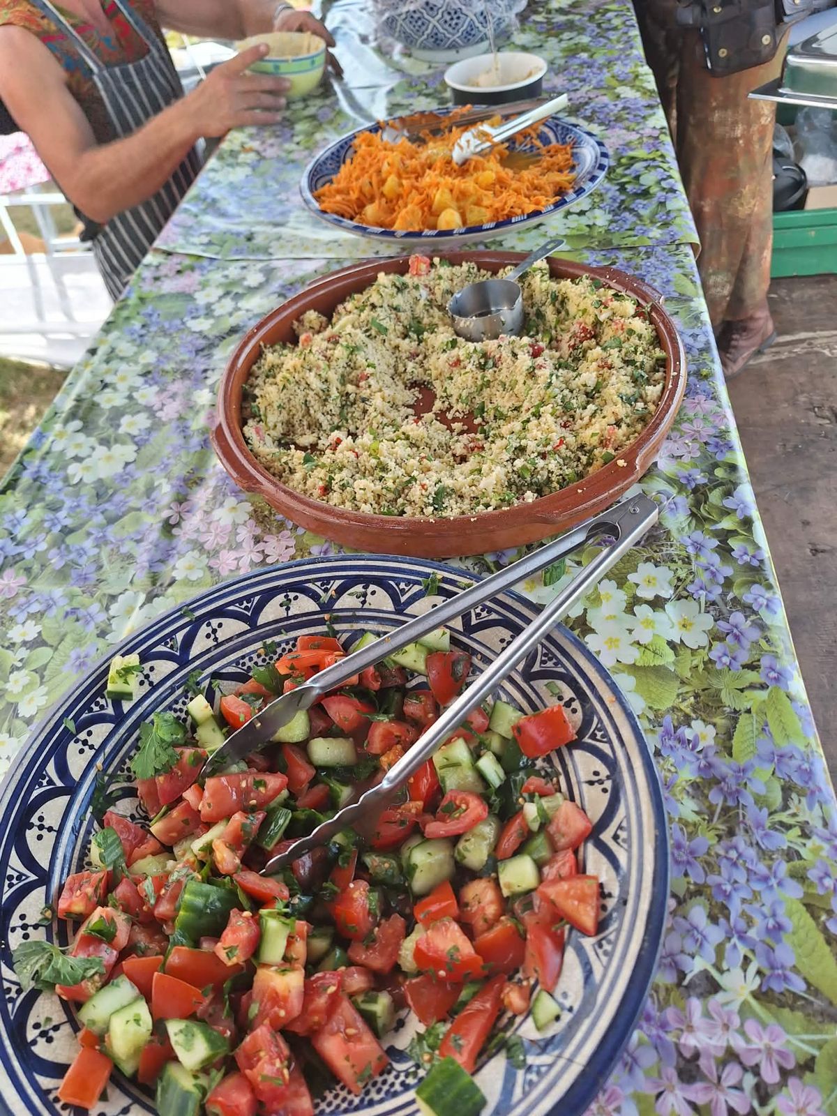 A long counter set with Israeli salad, Lebanese couscous tabbouleh and carrot, orange and ginger salad
